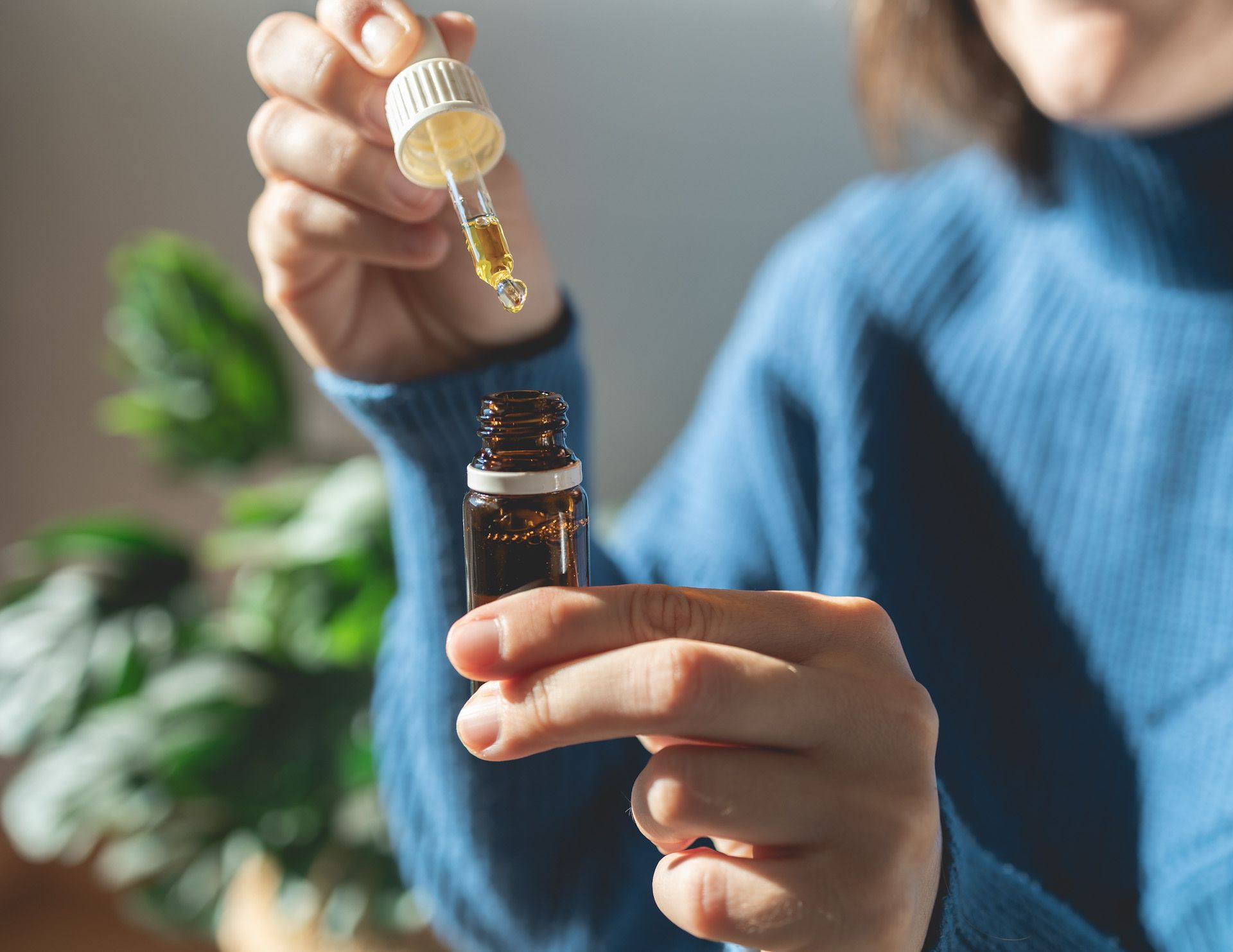 Woman holding bottle of cannabis oil for anxiety treatment