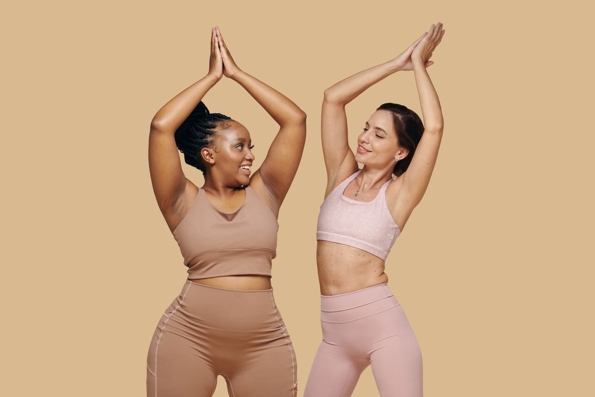 Two women are standing next to each other with their arms in the air.