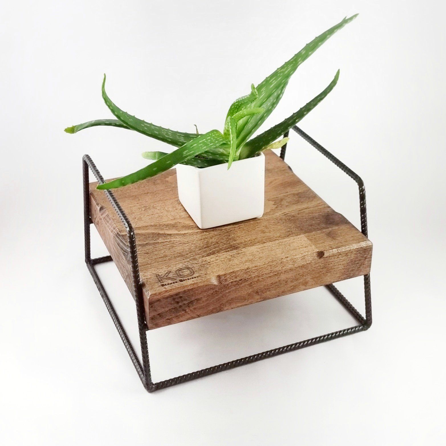 Op een houten tafel staat een potplant