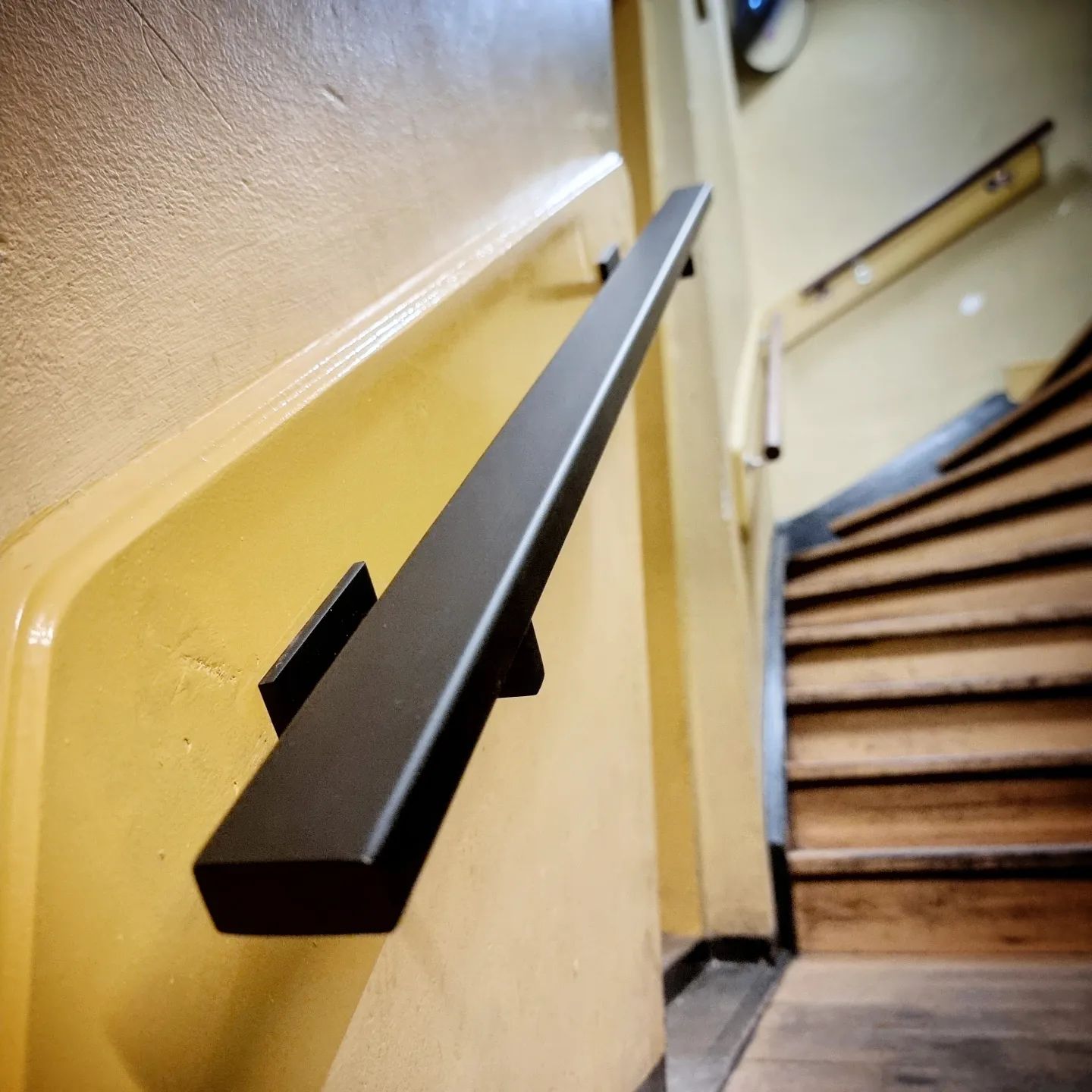 Trapleuning van staal met matzwarte poedercoating.