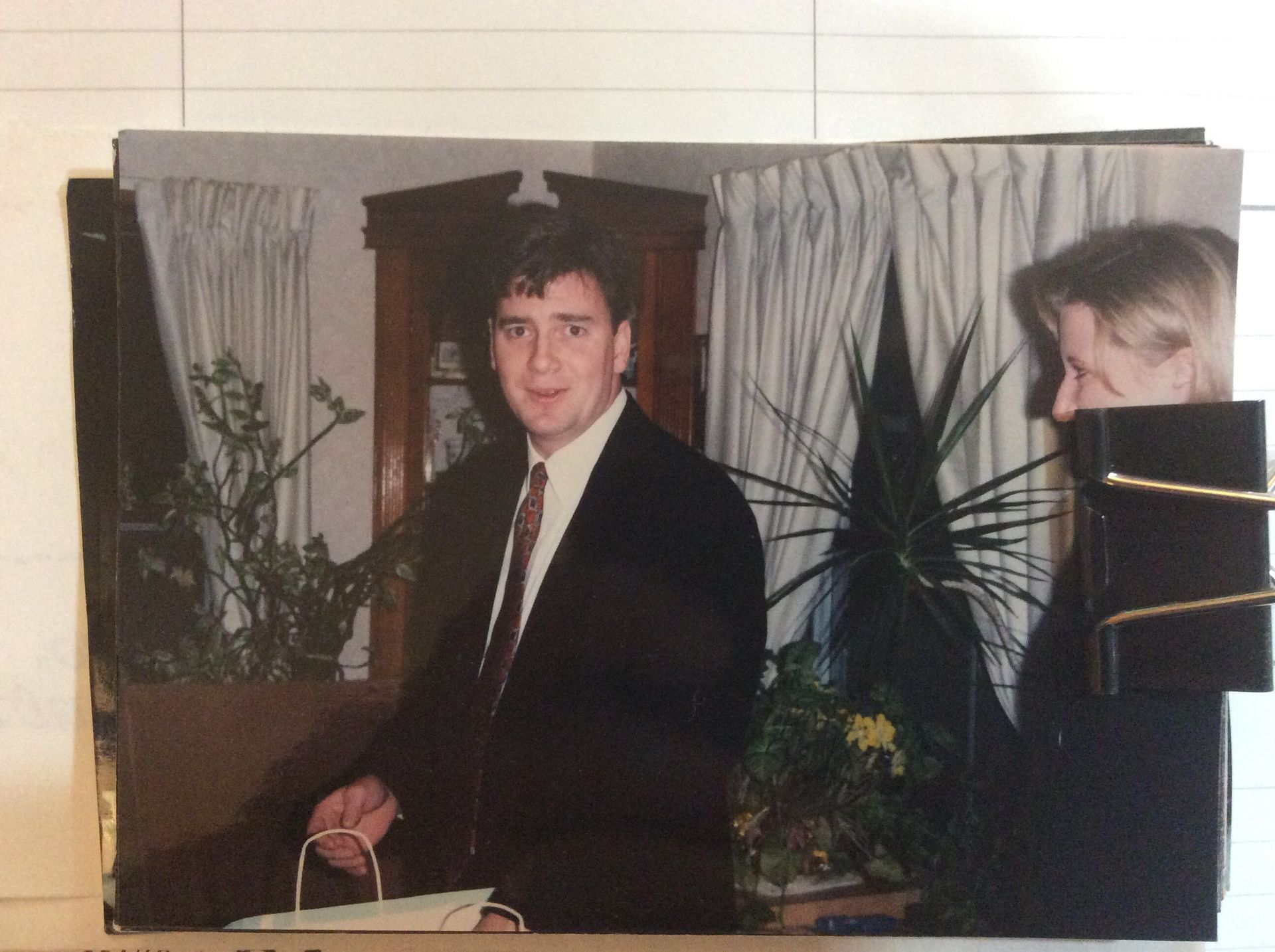 A man in a suit and tie is standing next to a woman