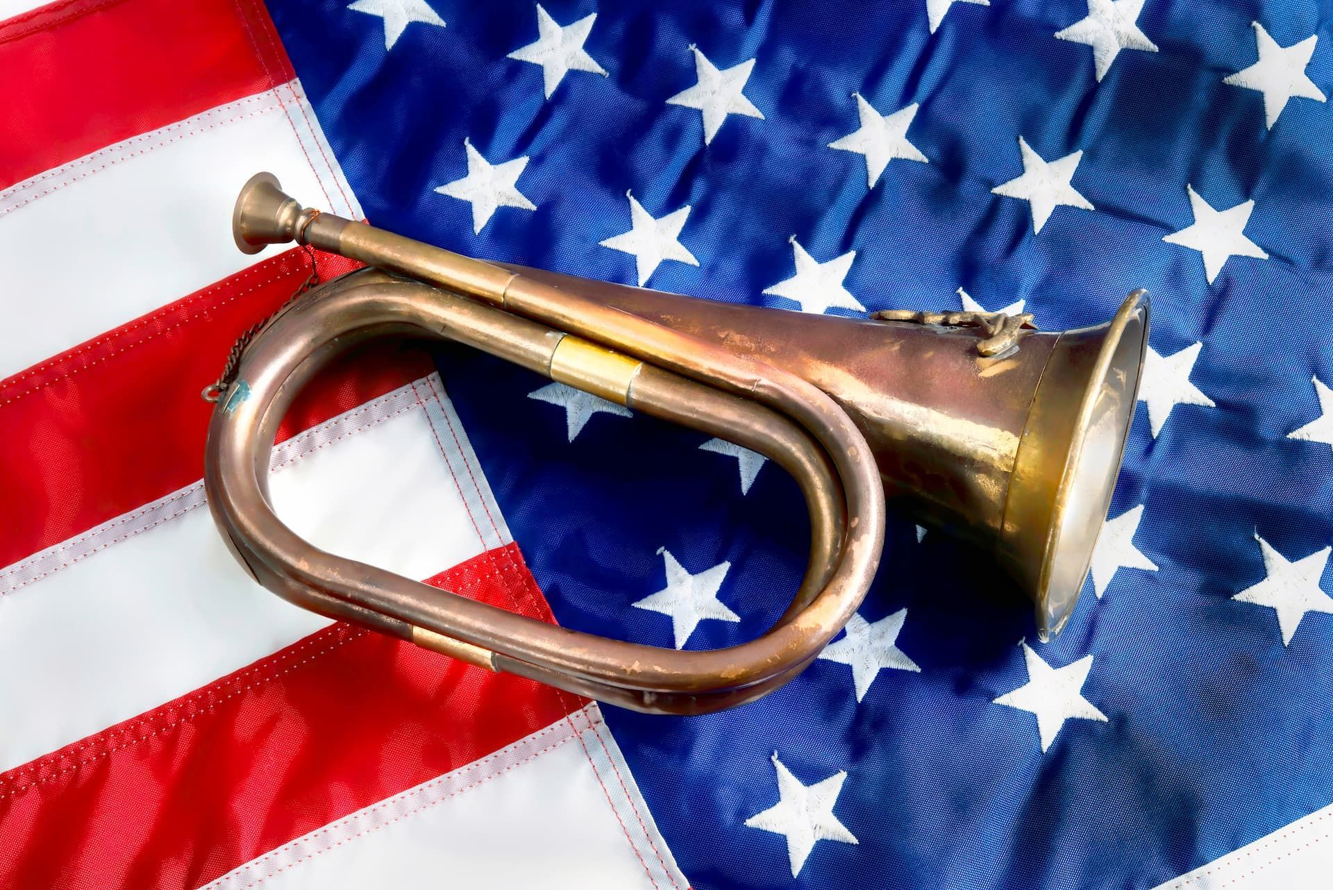 A trumpet is sitting on top of an american flag.