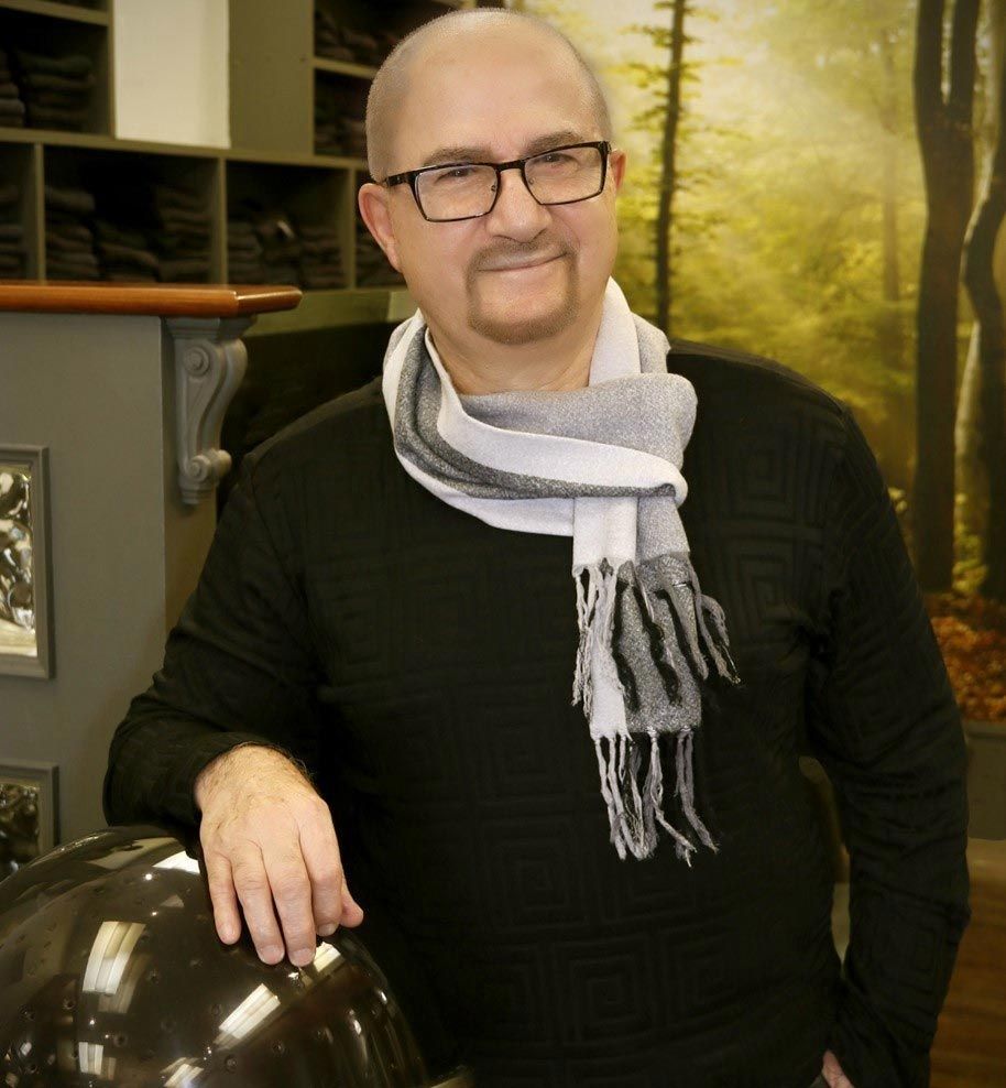 Un homme portant des lunettes et un foulard s'appuie sur un casque