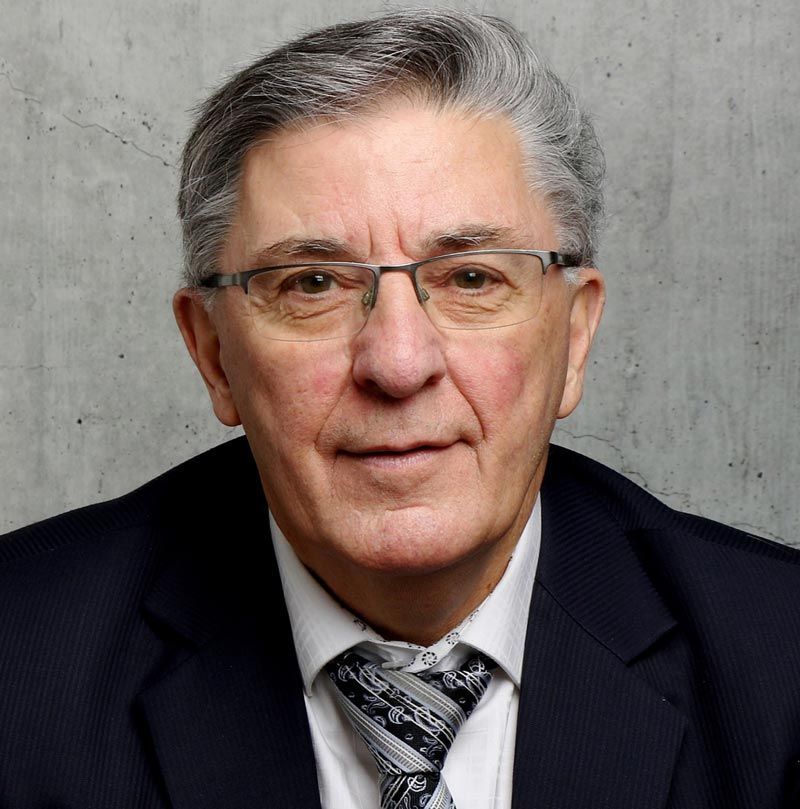 Un homme plus âgé portant des lunettes et un costume et une cravate