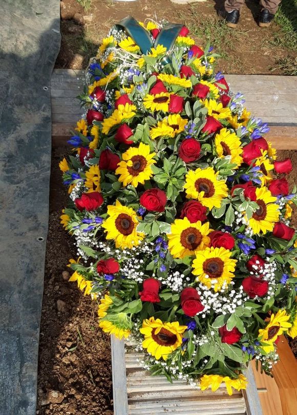 Cuscino di fiori colorati su bara in mogano