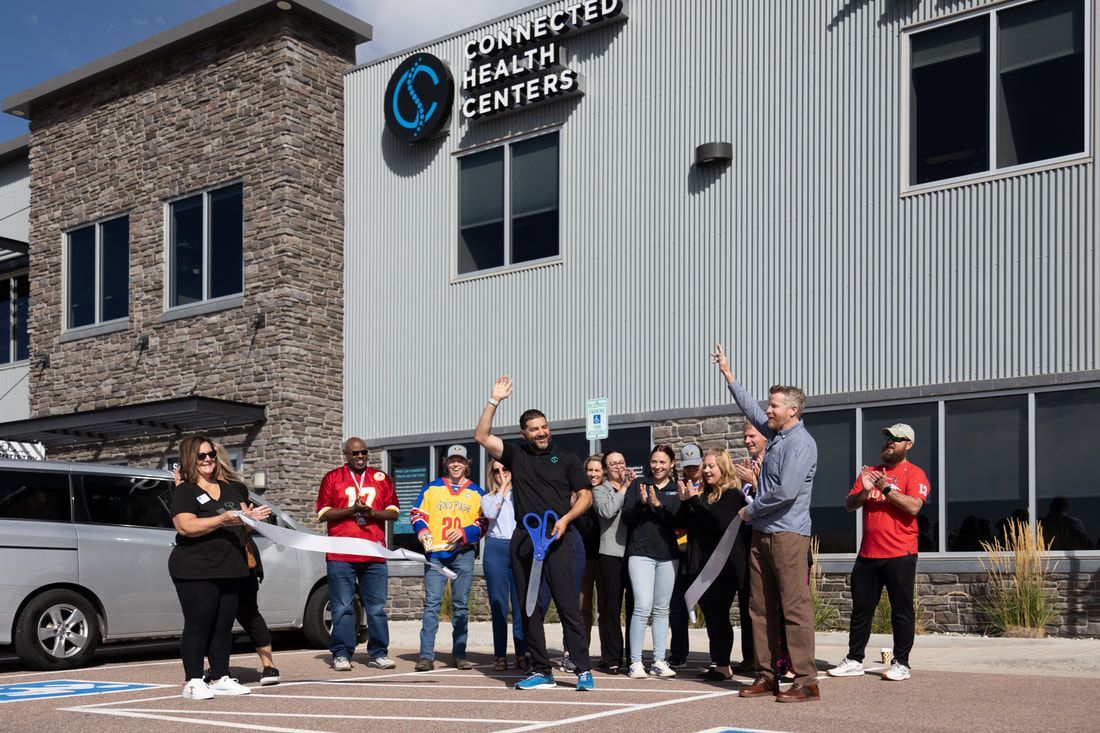 People celebrate a ribbon-cutting ceremony at the Connected Health Center.