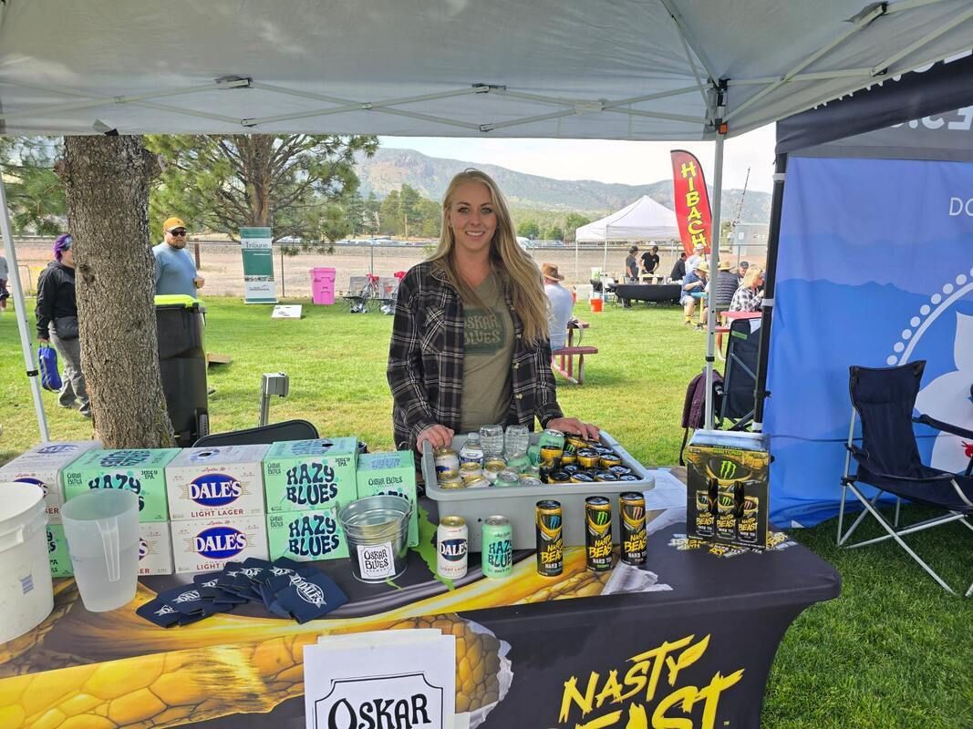 Woman at a beer booth, under a tent, selling 