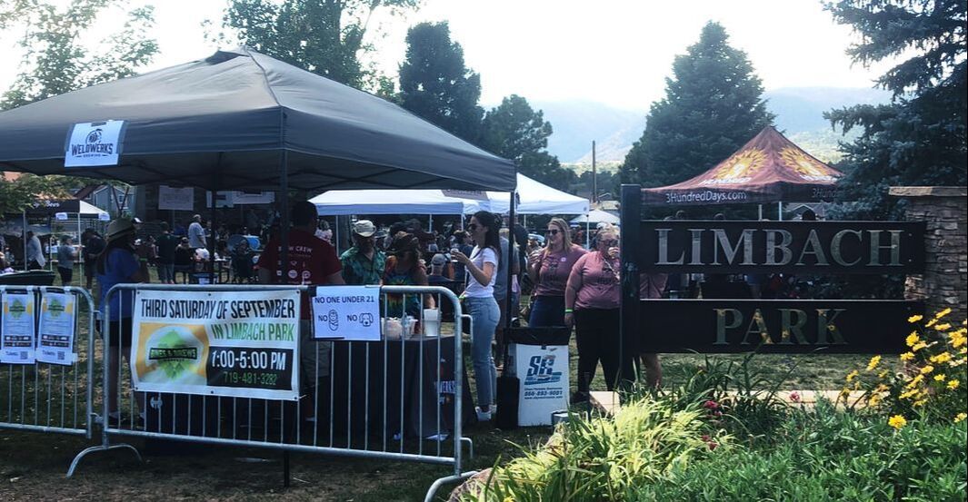Crowd at Limbach Park event with tents and signs. Green, orange, and white colors visible.