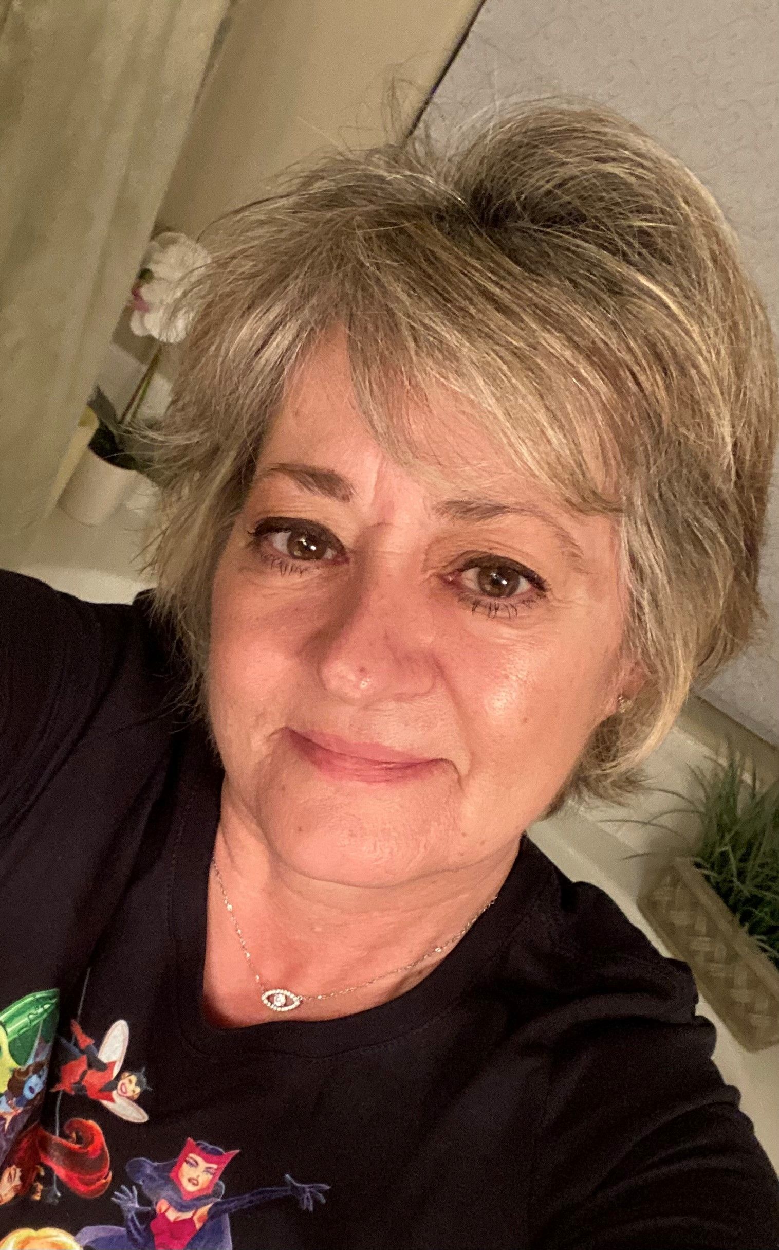 Woman with short, blonde hair, smiling at the camera.