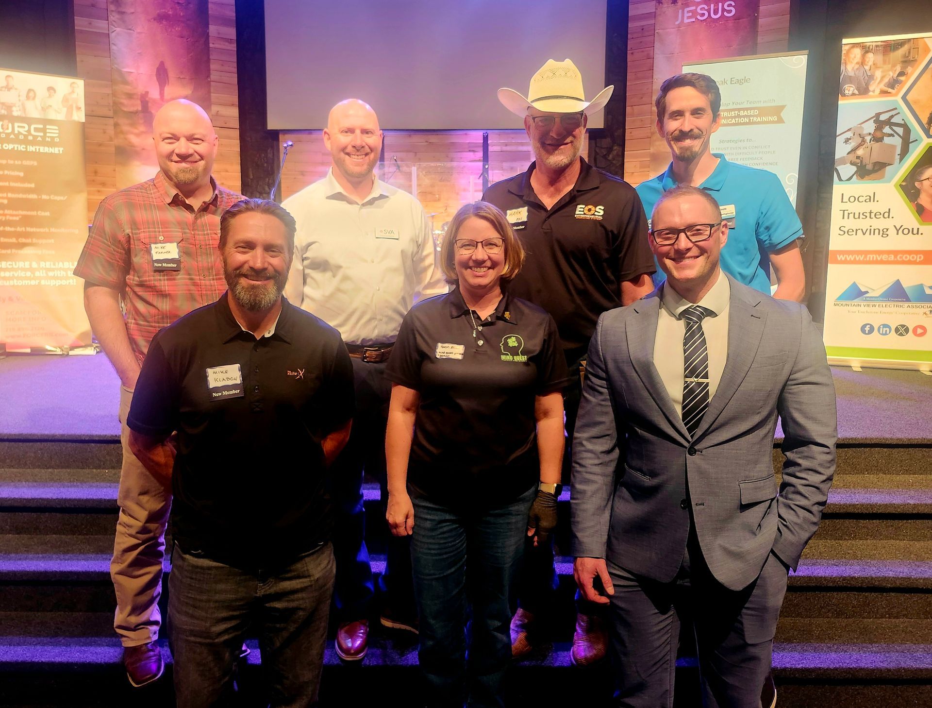 Group of diverse people standing on stage, smiling.