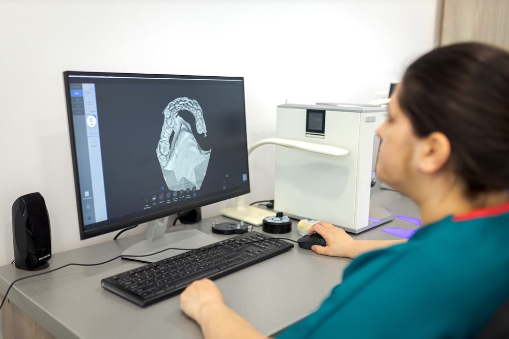 A woman is sitting at a desk using a computer.