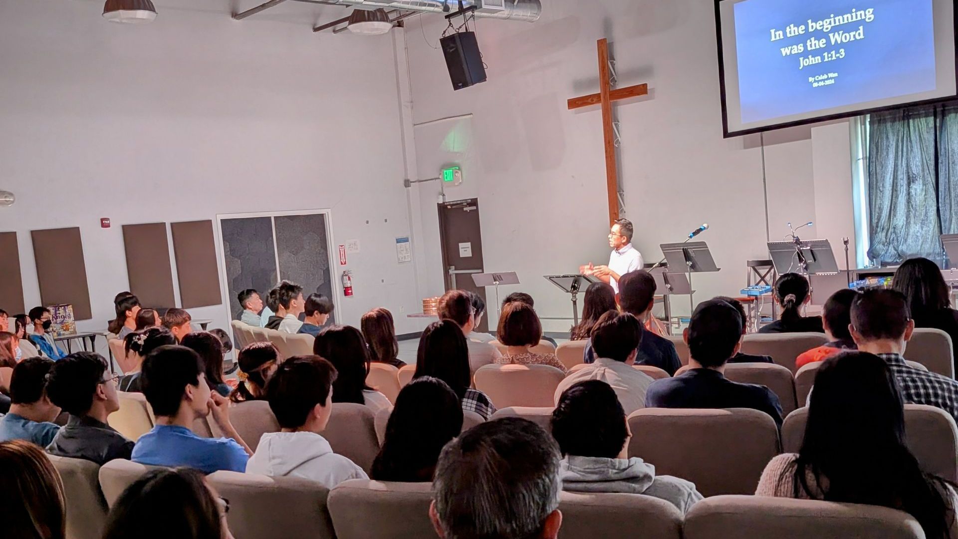 A group of people are sitting in an auditorium watching a presentation.