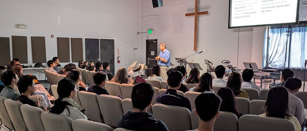 A group of people are sitting in an auditorium watching a presentation.