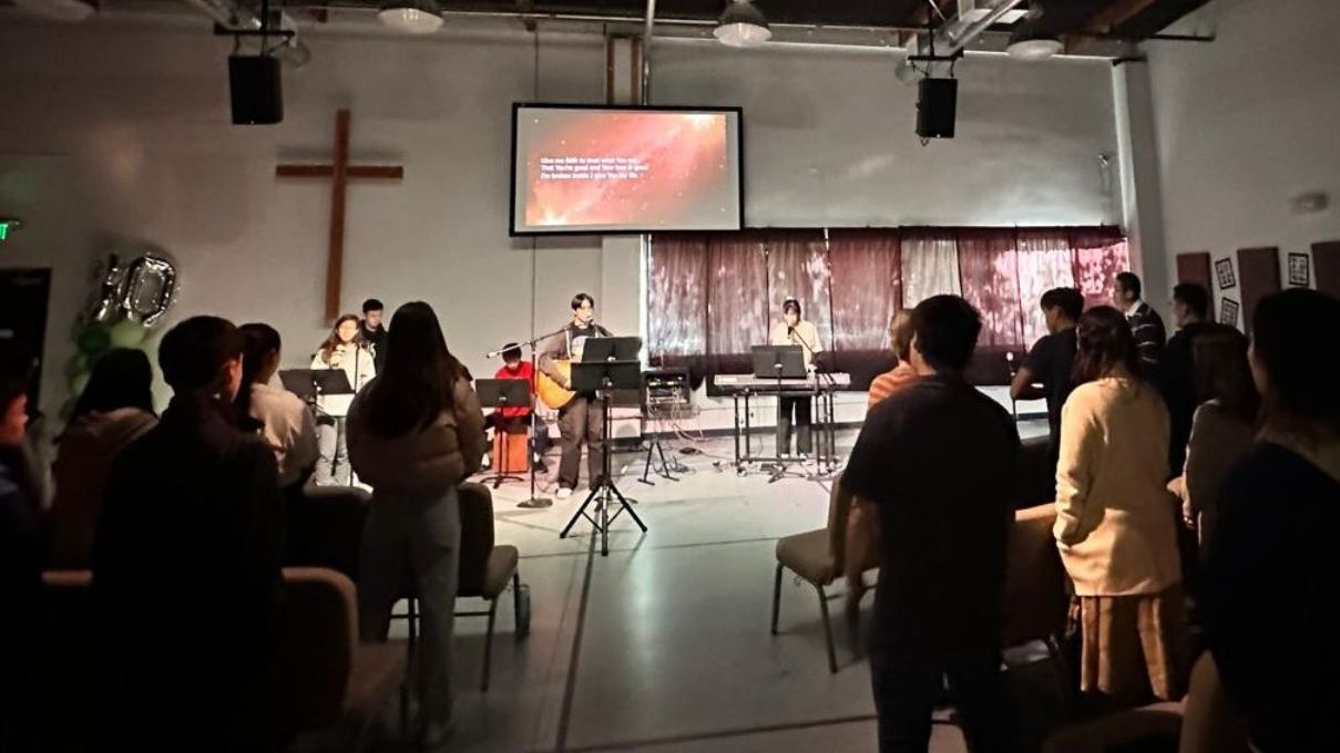 A group of people are sitting in a church watching a concert.