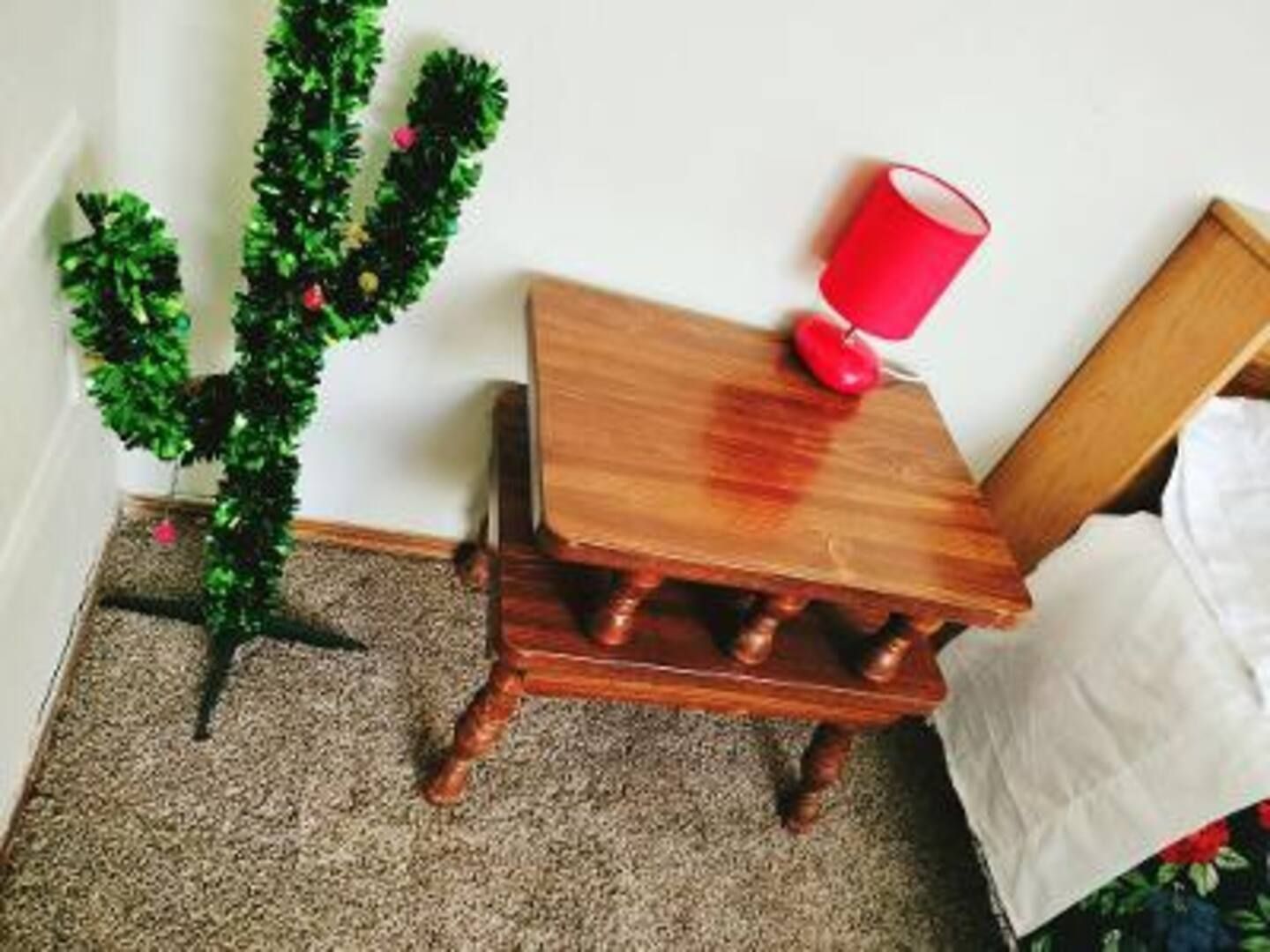A small wooden table with a red lamp on it