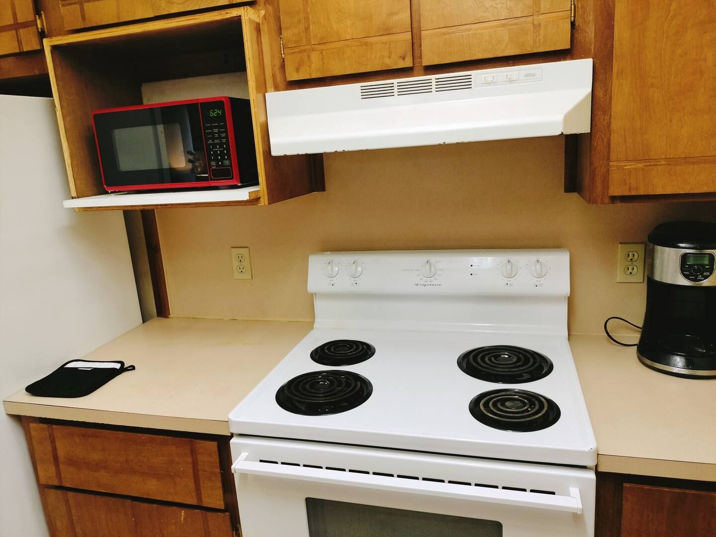 A kitchen with a stove top oven and a microwave