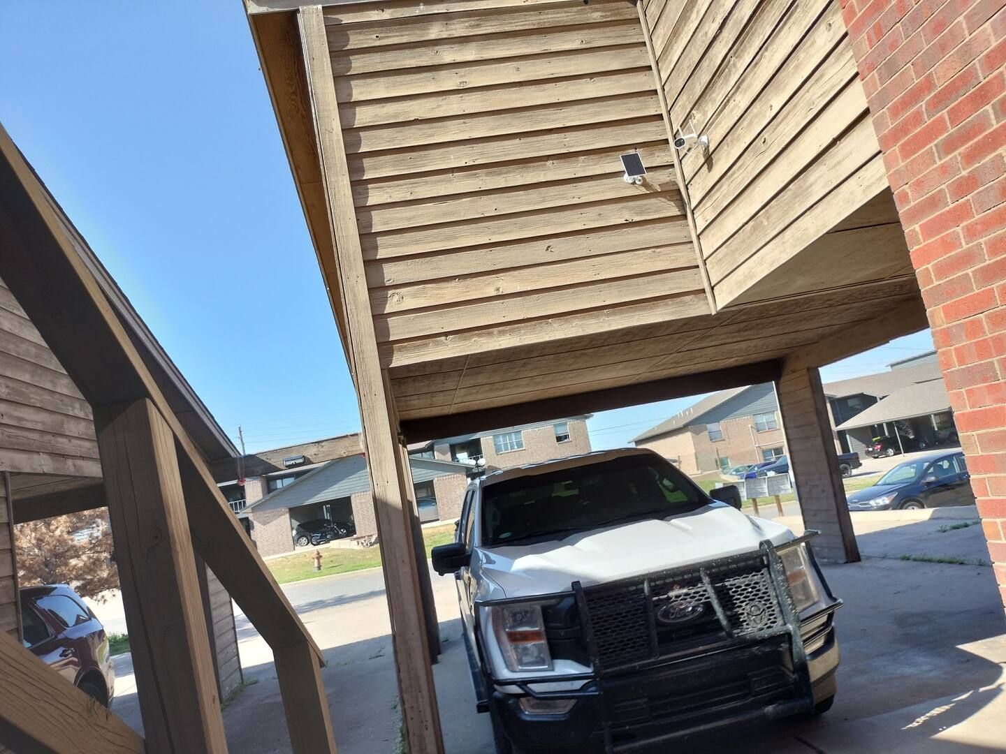 A white suv is parked under a staircase