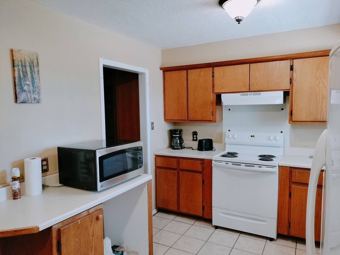 A kitchen with a stove a microwave and a refrigerator