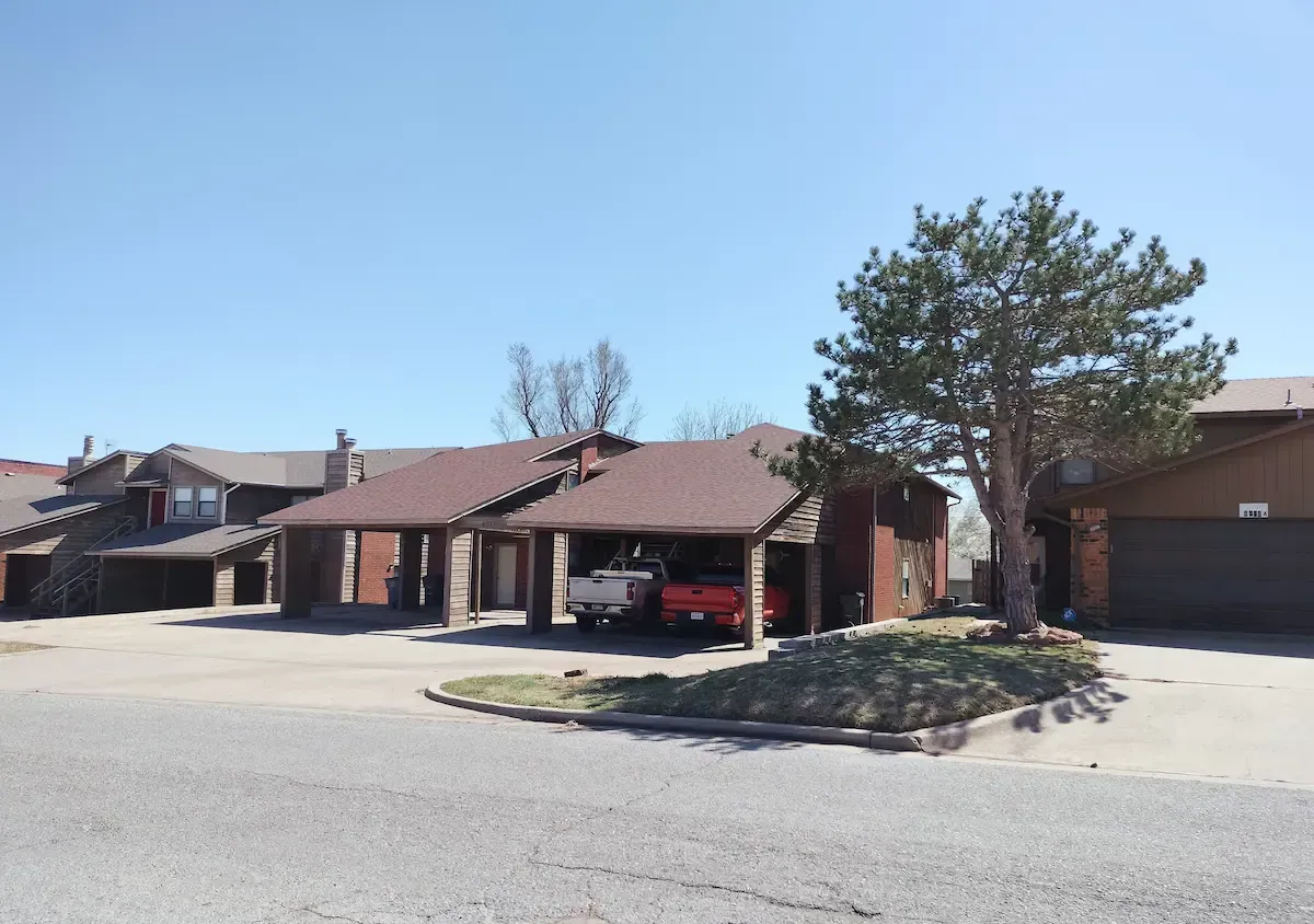A red truck is parked in front of a row of houses