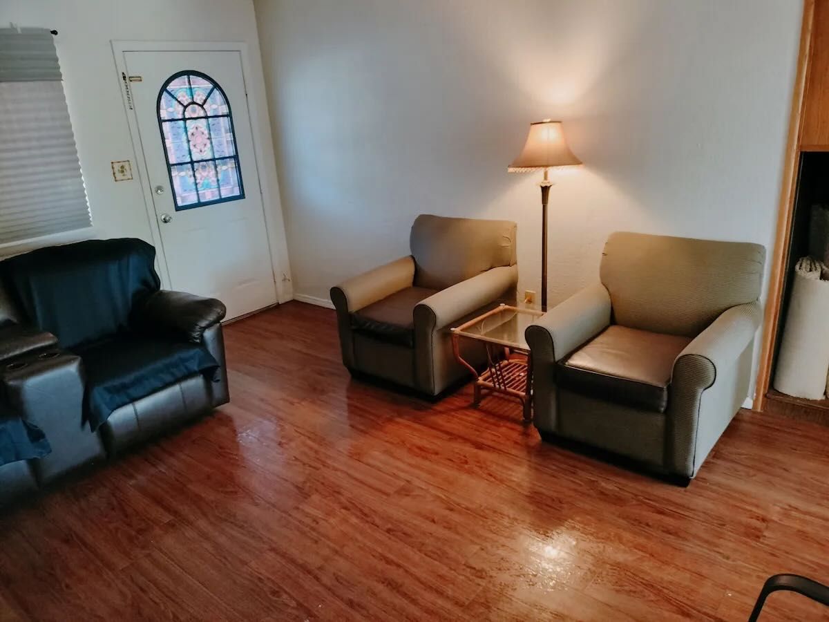 A living room with two chairs and a lamp