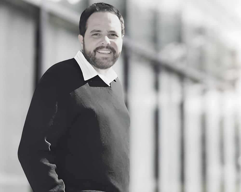 A man with a beard is wearing a black sweater