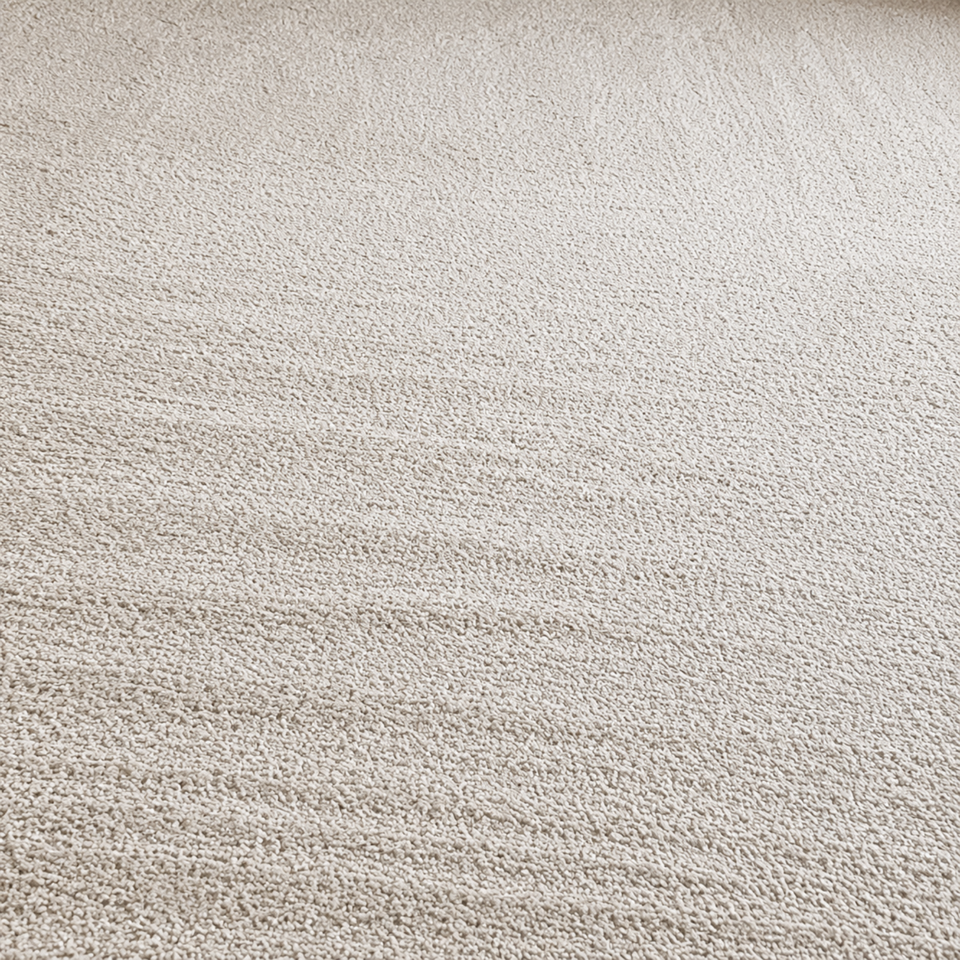 Close-up of a light beige textured fabric surface with a subtle woven pattern
