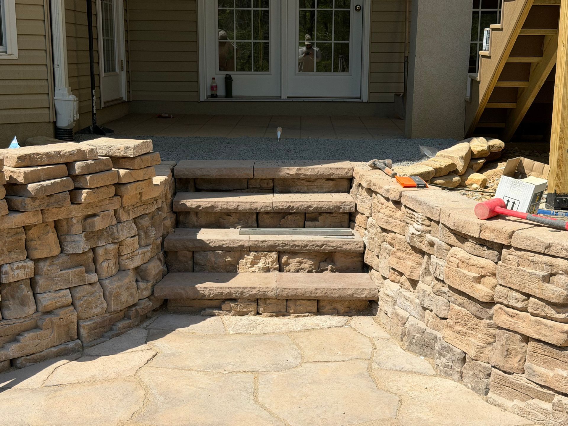 Stone steps and retaining walls leading to a front porch entrance