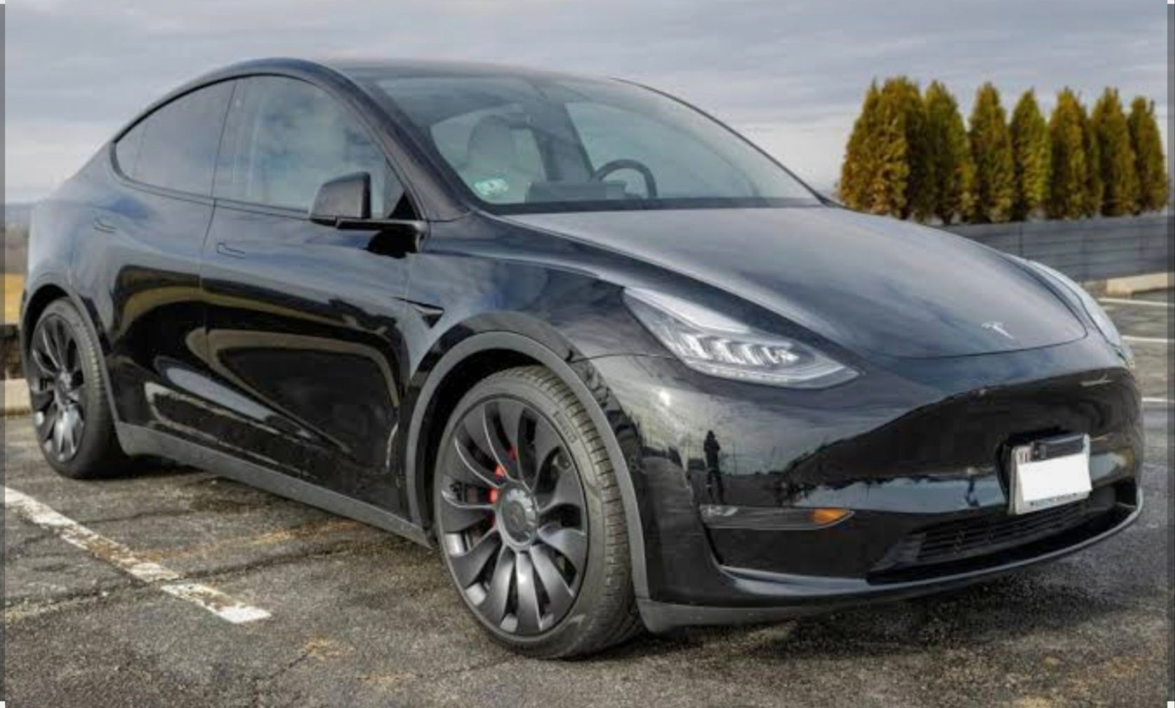A black tesla model s is parked in a parking lot.