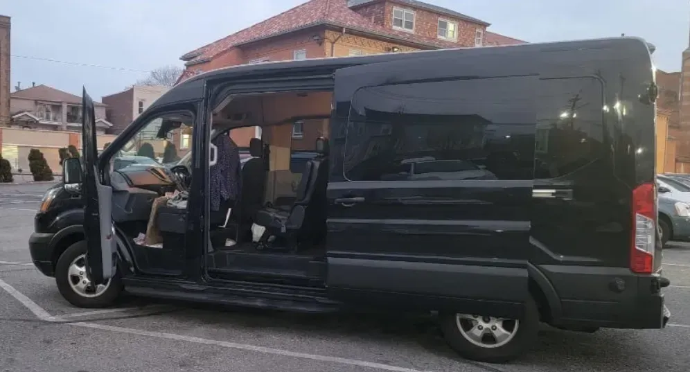 A black van is parked in a parking lot with its doors open.