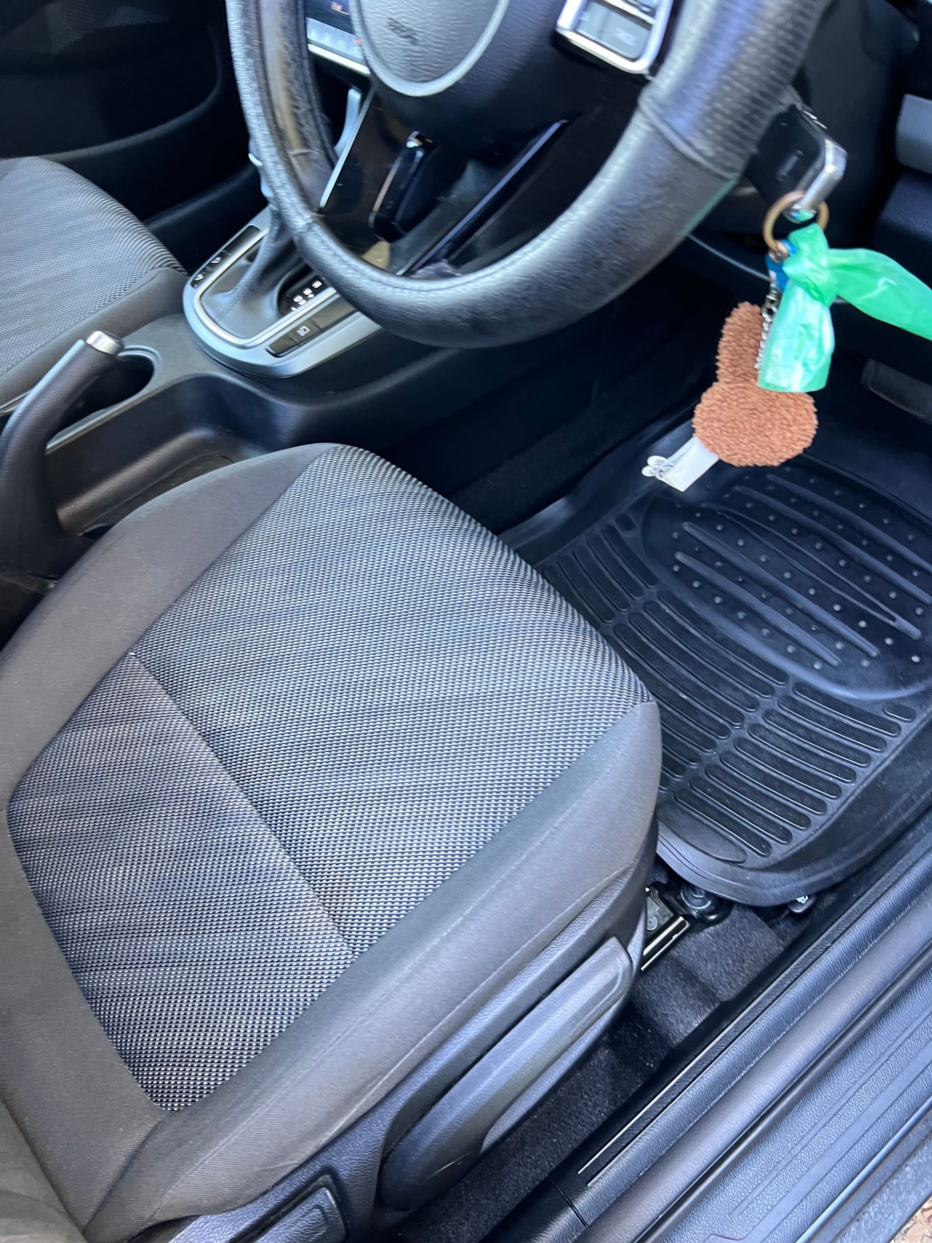 Car Interior With Steering Wheel, Black Seat, Floor Mat, And A Hanging Keychain Near The Ignition — Car Detailing Mobile Cleaning Co In Lake Cathie, NSW