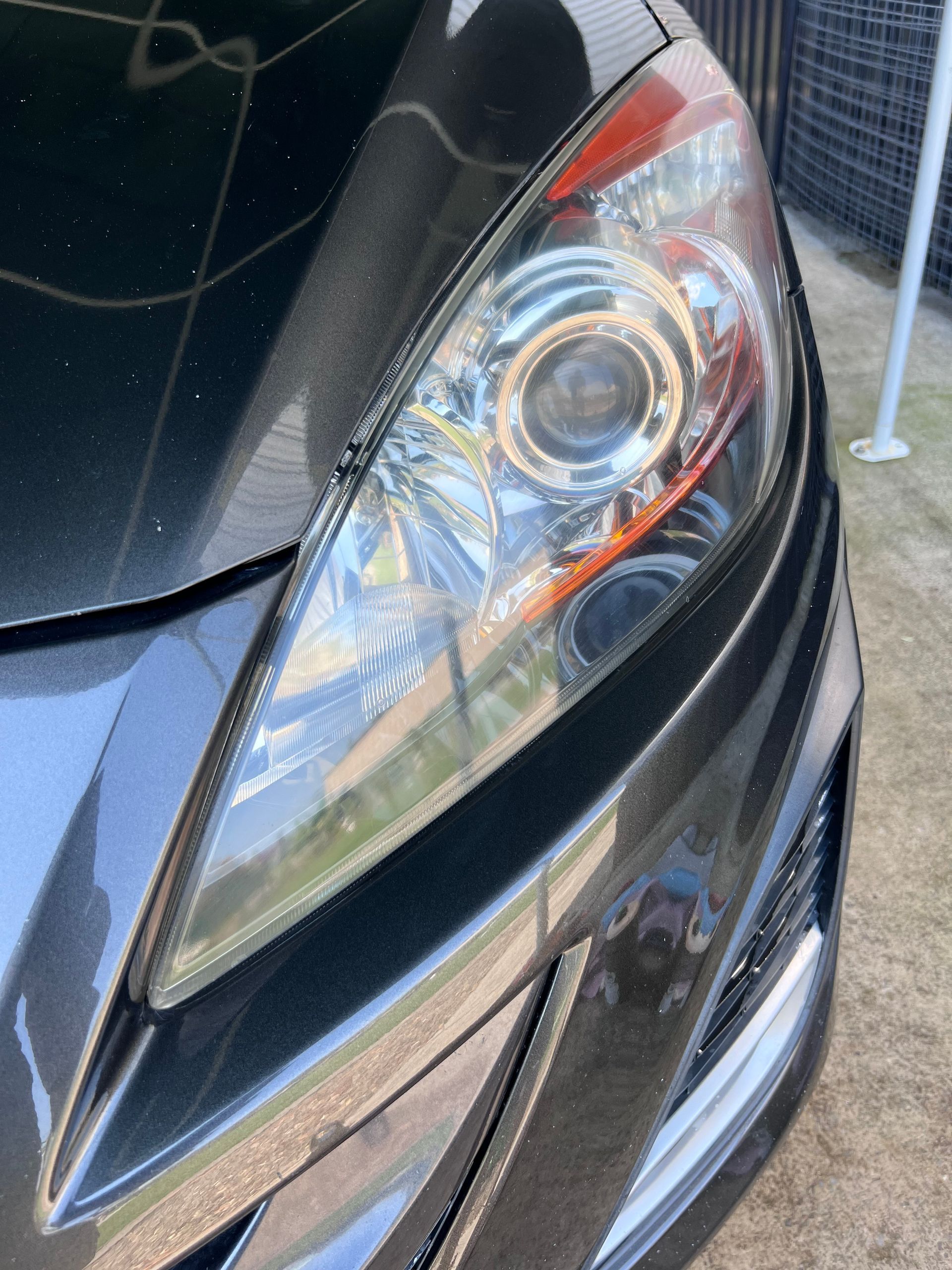 Close-up Of A Black Car’s Front Headlight And Fender In Sunlight — Car Detailing Mobile Cleaning Co In Wauchope, NSW