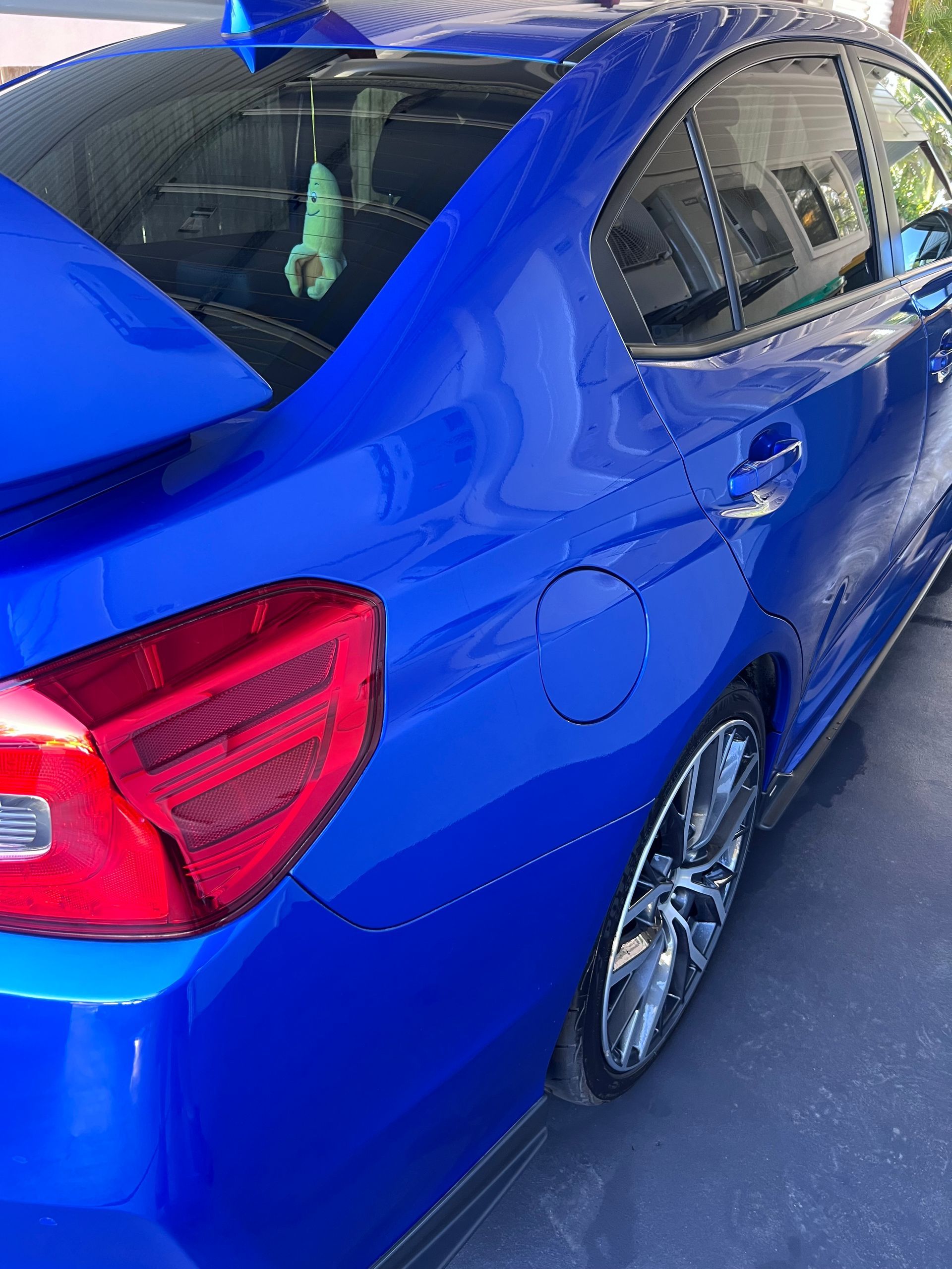 Blue Sedan Parked In A Driveway, Rear Side View With Red Taillight And Reflective Windows — Car Detailing Mobile Cleaning Co In Wauchope, NSW