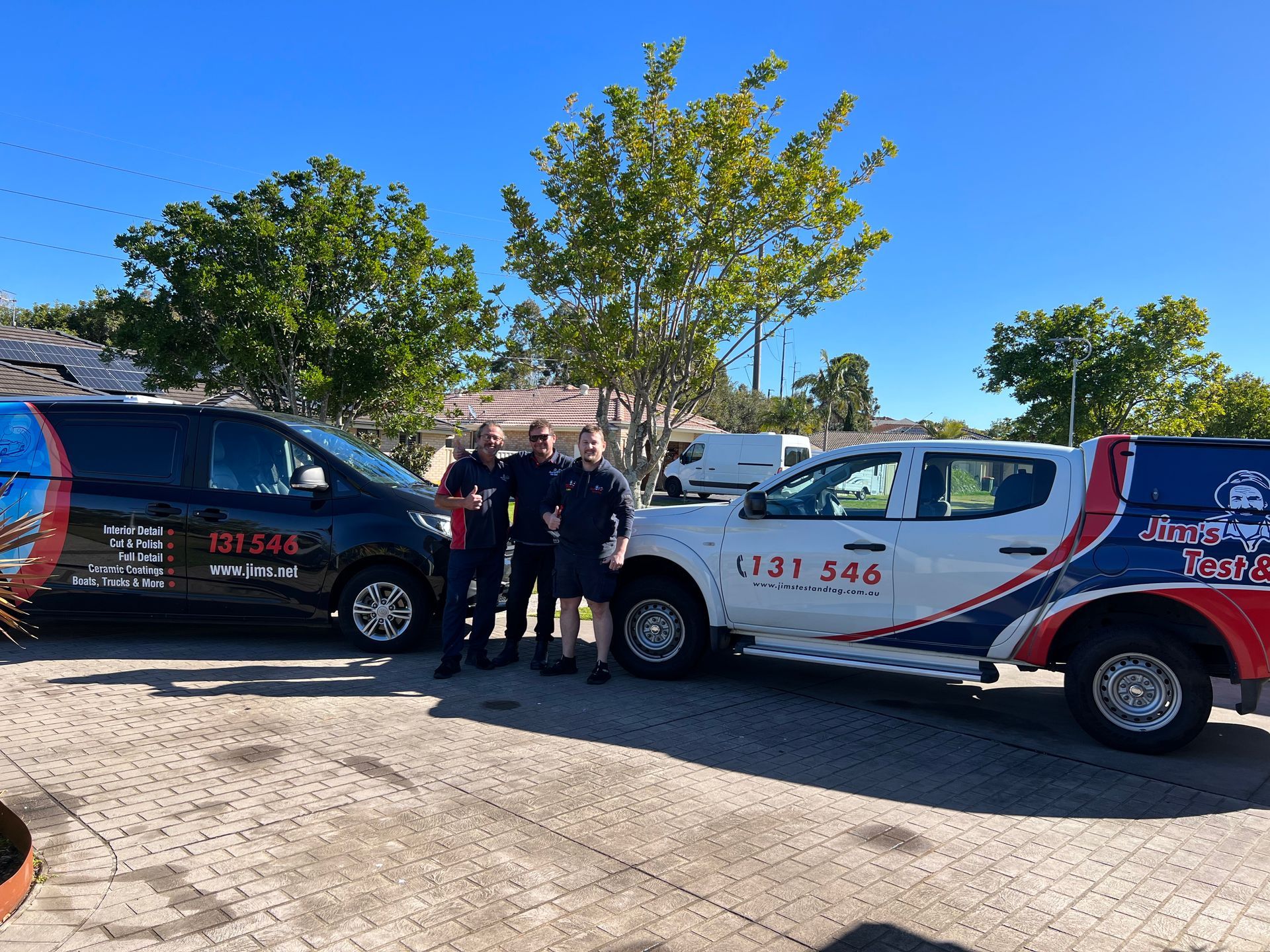 Two parked vans with three people standing between them — Car Detailing Mobile Cleaning Co In Port Macquarie, NSW