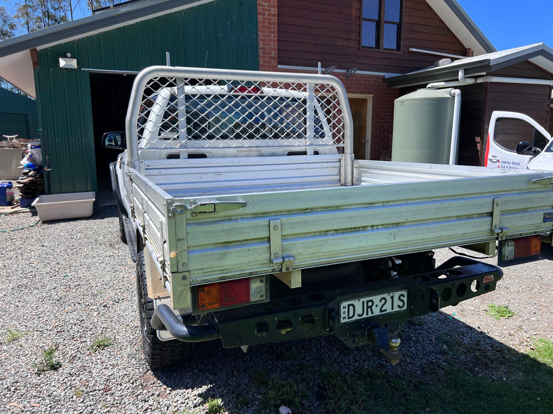 Rear View of a Silver Flatbed Pickup Truck Parked on Gravel — Car Detailing Mobile Cleaning Co In Lake Cathie, NSW