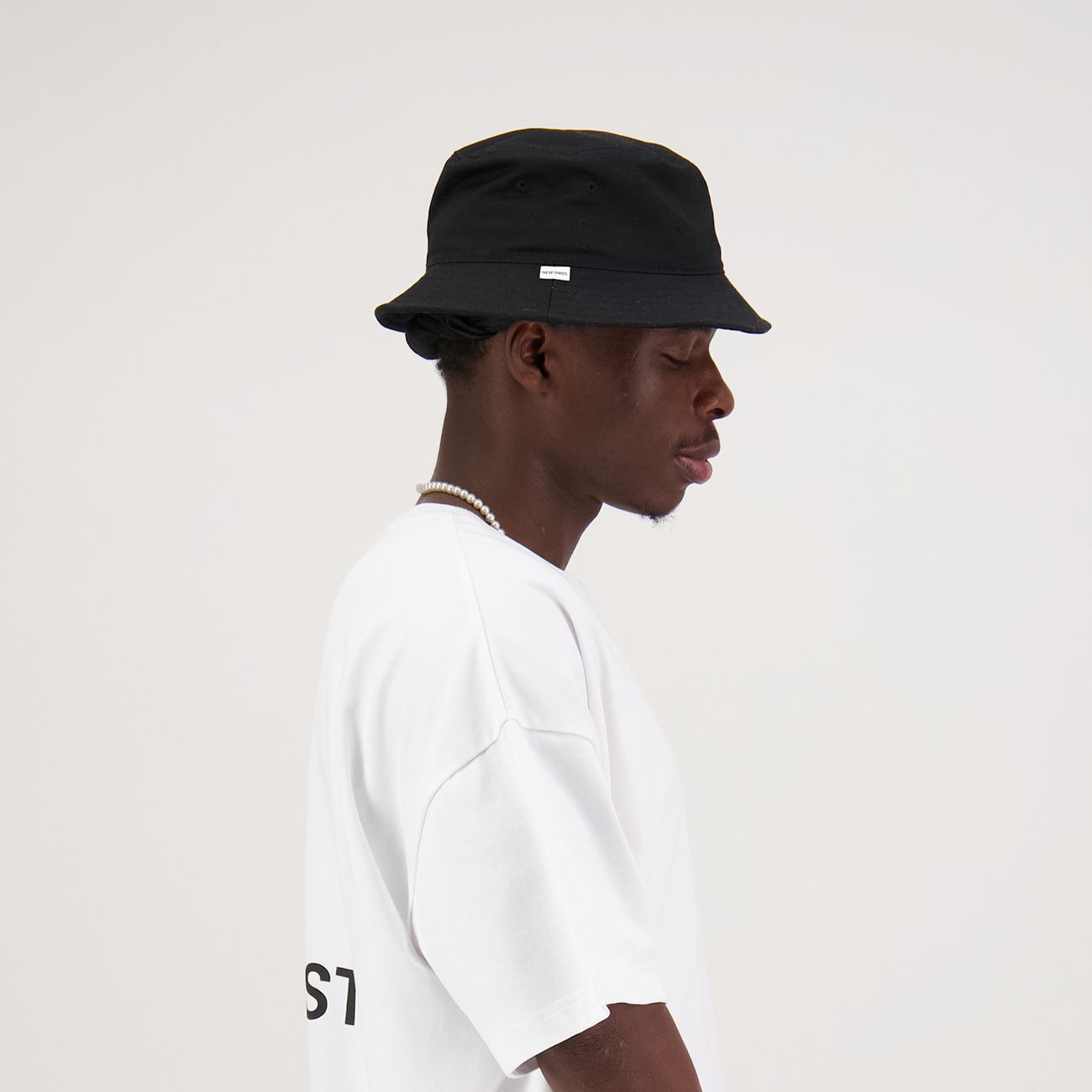 Black bucket hat with a small white tag on the brim.