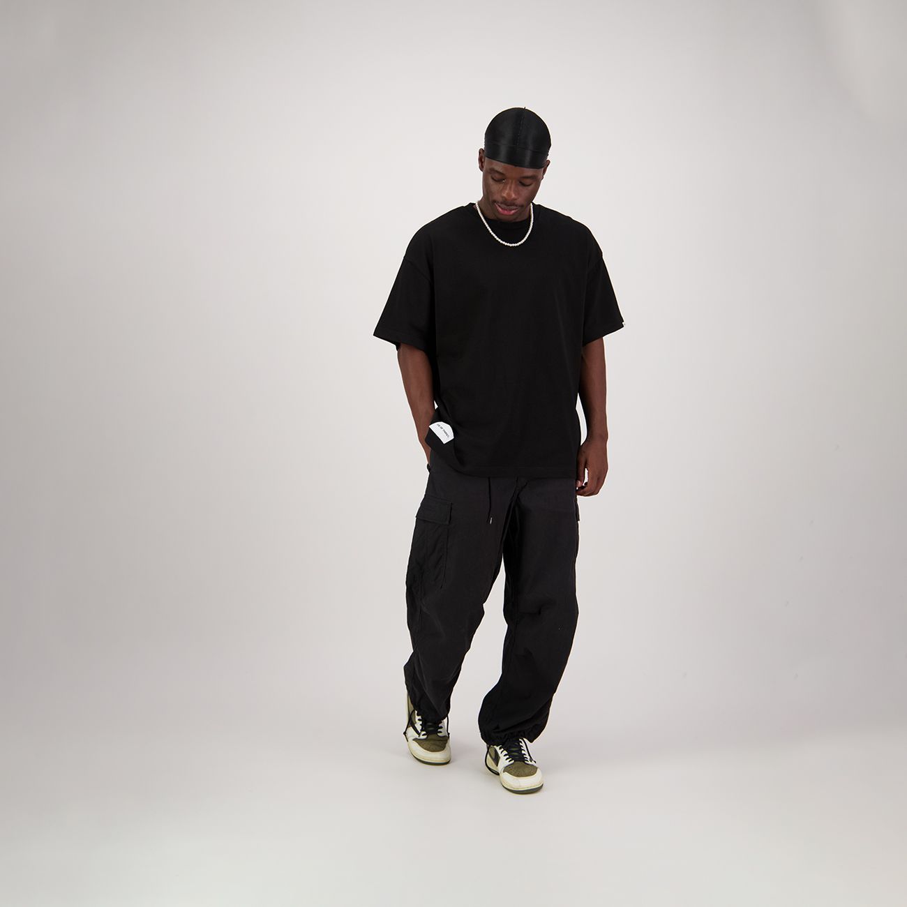 Black oversized t-shirt with a small tag on the bottom left and a label on the back neckline.