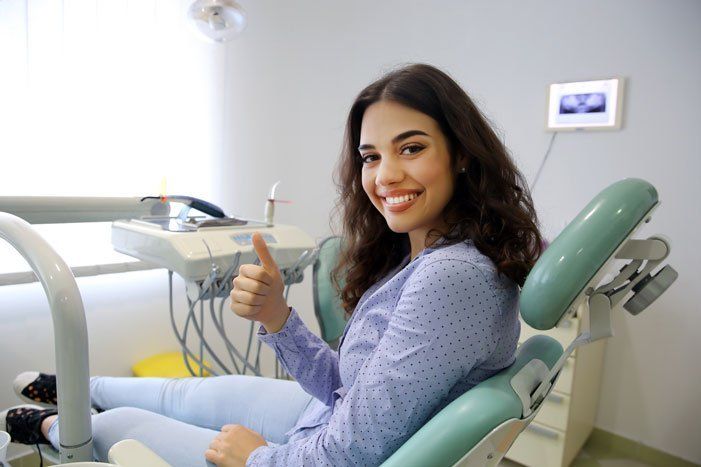 Smiling Woman on a Dental Chair — Orange, CT — New England Dental Health Services PC