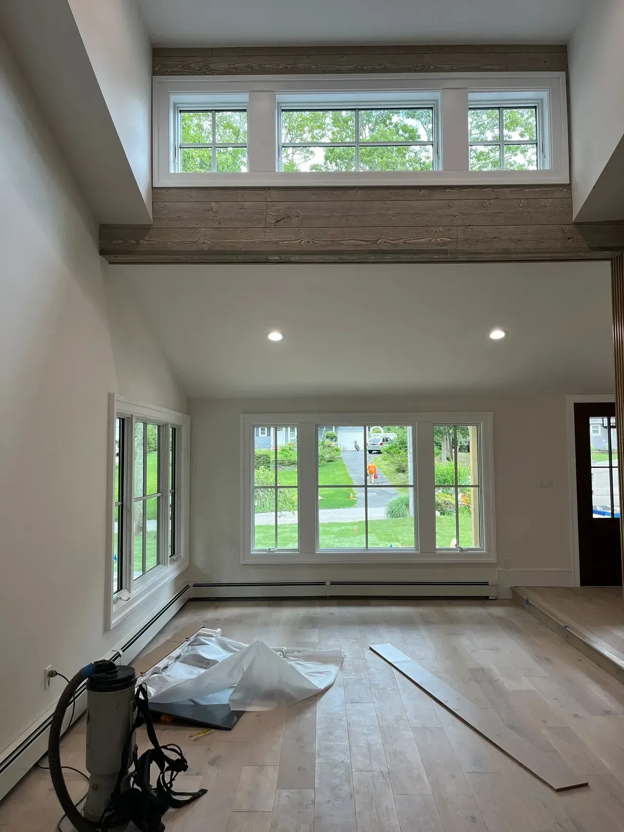 An empty living room with a vacuum cleaner on the floor