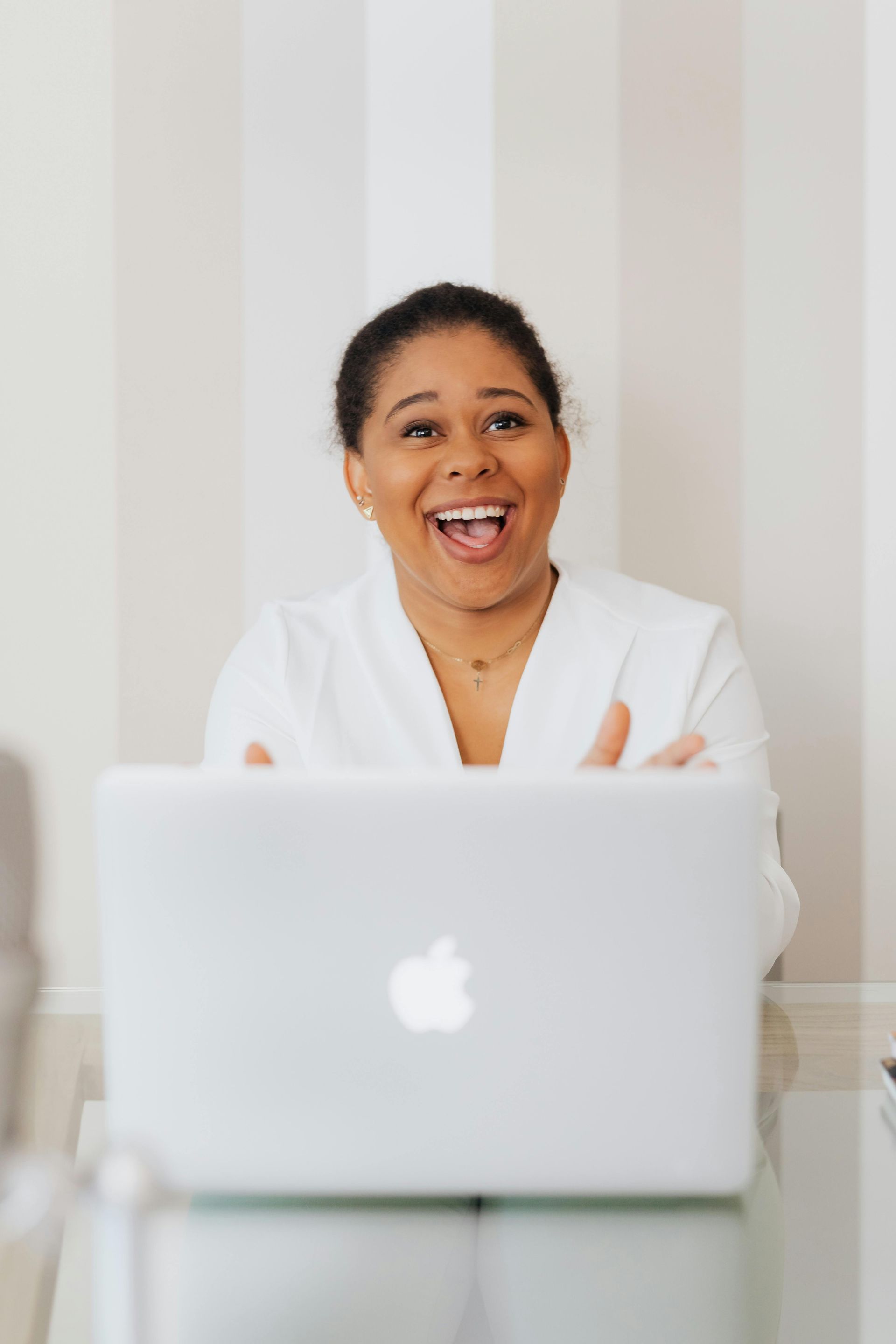 A woman is sitting at a table with a laptop computer.
