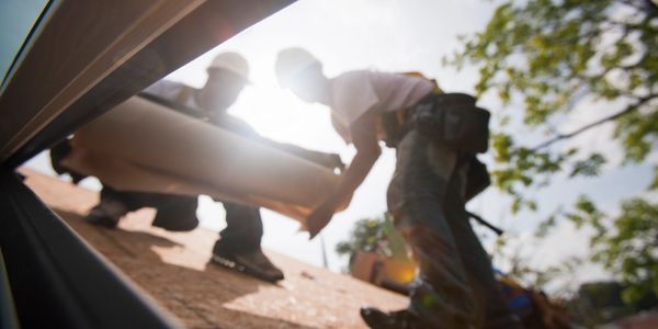Two Constantine Roofing workers performing roofing replacement on a roof in Shelby Township, MI.
