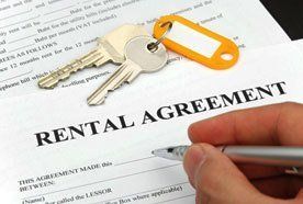 A set of house keys resting on a Rental Agreement