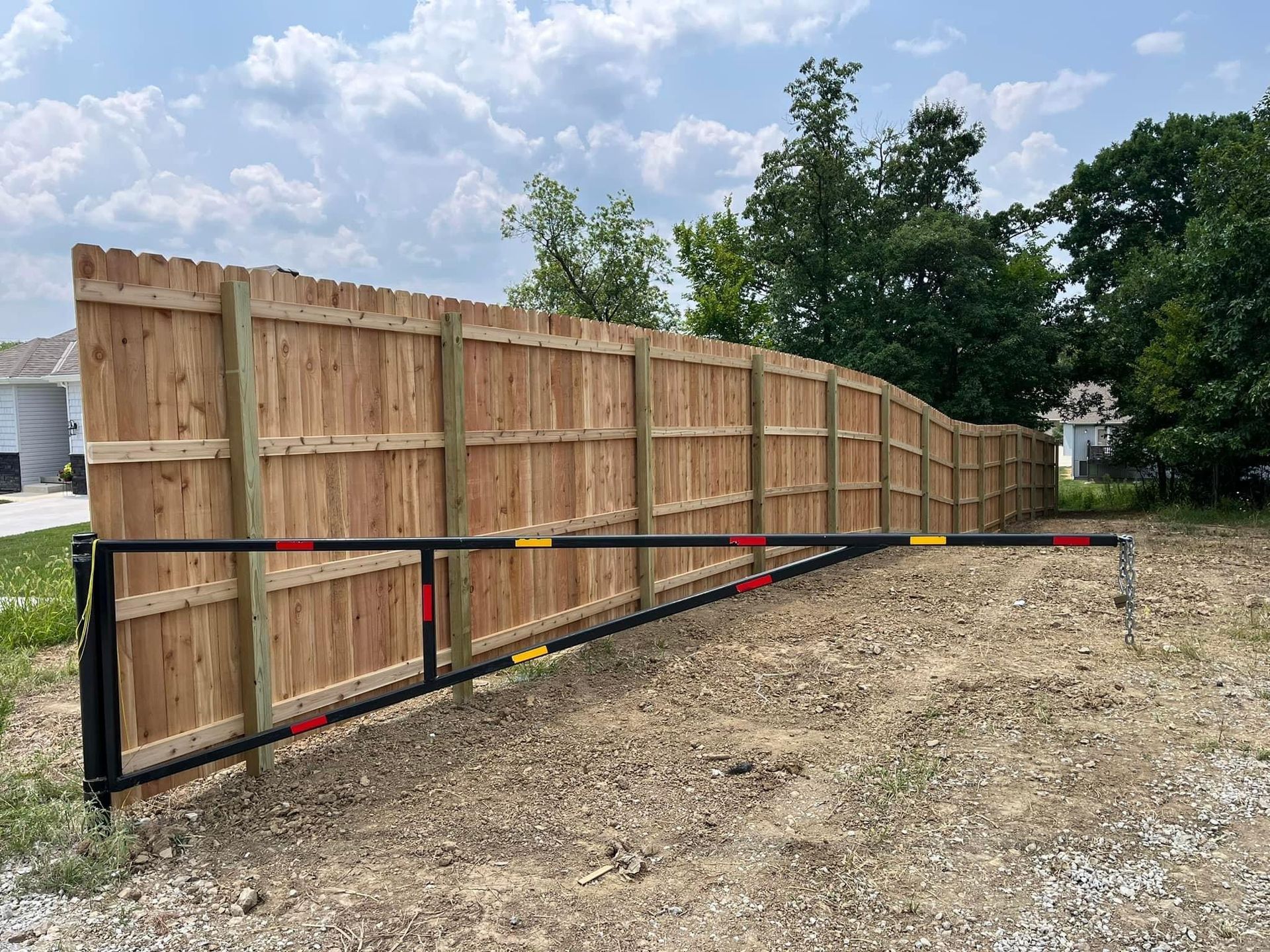 A wooden fence is sitting in the middle of a dirt field.