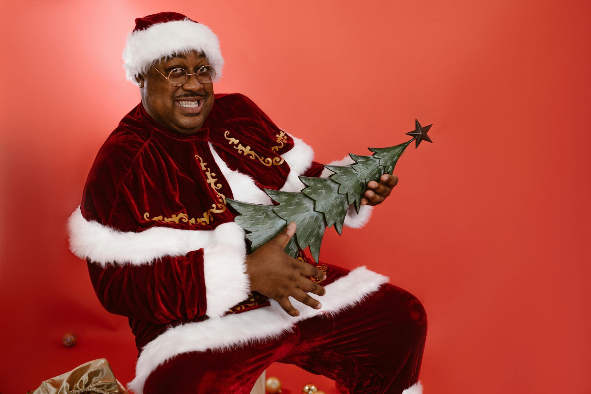 Santa rocking out and playing a Christmas tree like an electric guitar.
