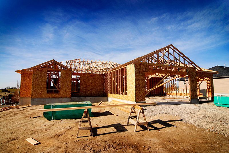 a house is being built in the middle of a dirt field .