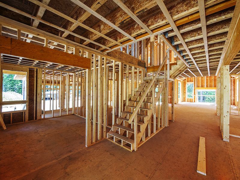 a house is being built with wooden beams and stairs .