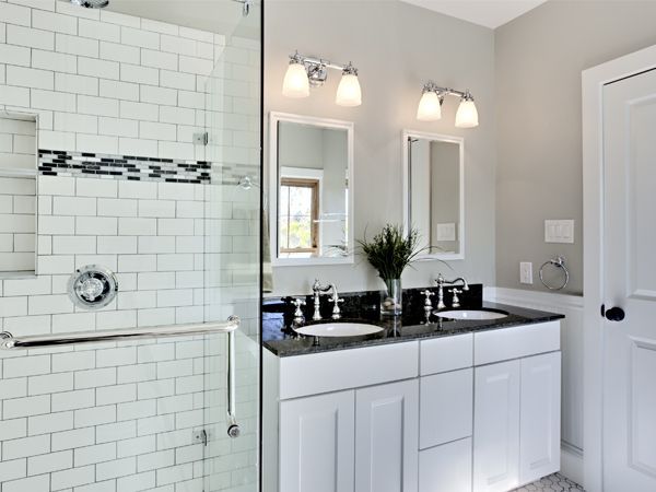 a bathroom with two sinks and a walk in shower .
