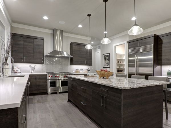 a kitchen with a large island and stainless steel appliances