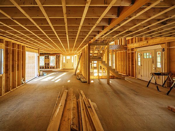 a house is being built with wooden beams and a staircase .