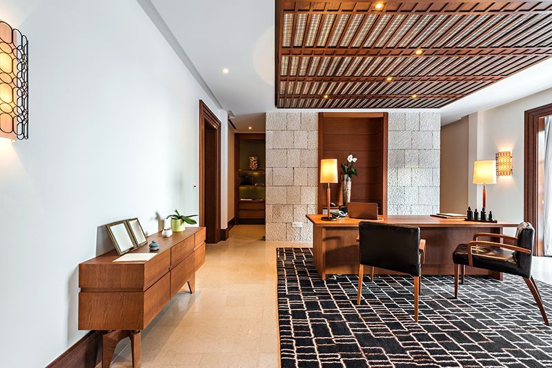 a living room with a desk and chairs in it