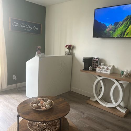 A living room with a table and a flat screen tv.